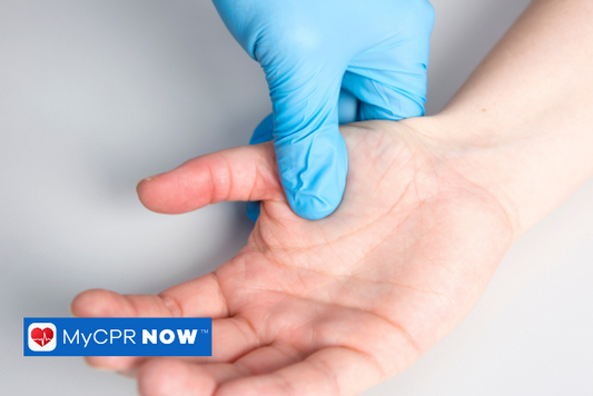 A latex glove is measuring capillary refill on a patient near the thumb