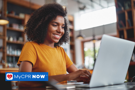 A woman with yellow shirt typing on a laptop